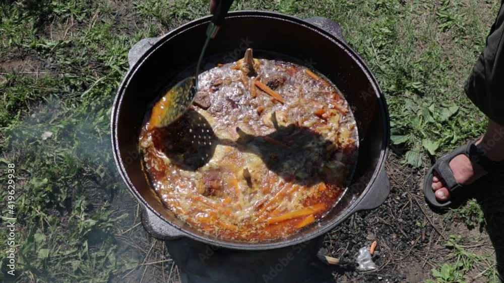 pilaf in a cauldron on fire an oriental dish on a sunny day pilaf in a cauldron on fire an oriental dish on a sunny day