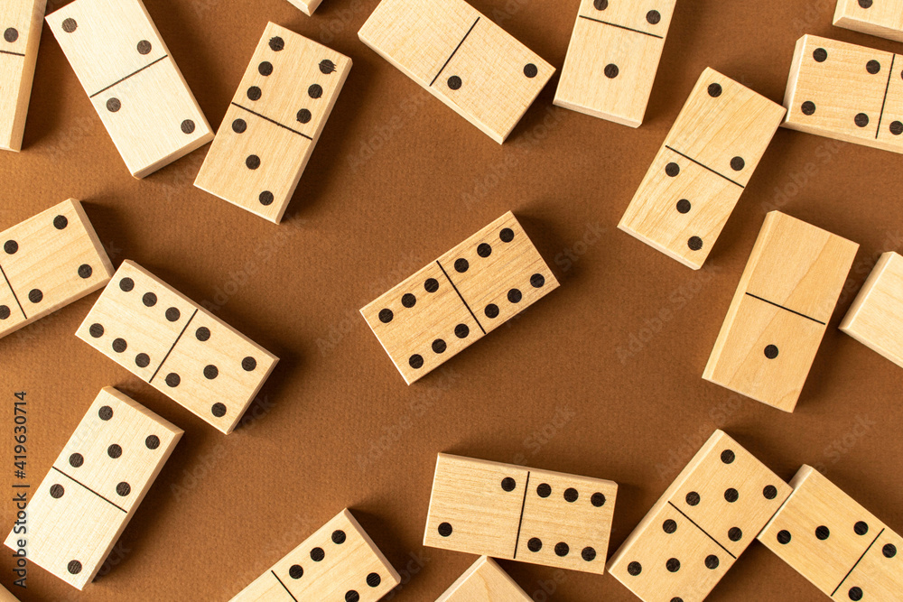 A game of dominoes on a brown background. Close-up. Selective focus. A game of dominoes on a brown background. Close-up. Selective focus.