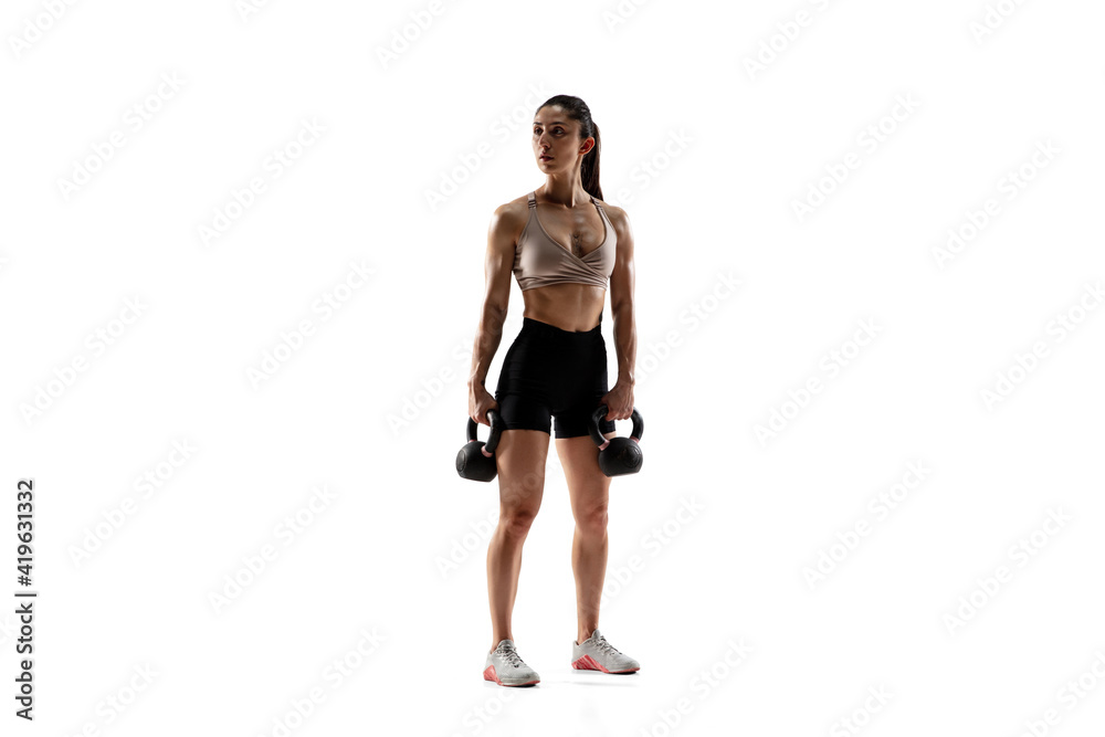 Dumbbells. Caucasian professional female athlete training isolated on white studio background. Muscular, sportive woman. Concept of action, motion, youth, healthy lifestyle. Copyspace for ad. Dumbbells. Caucasian professional female athlete training isolated on white studio background. Muscular, sportive woman. Concept of action, motion, youth, healthy lifestyle. Copyspace for ad.