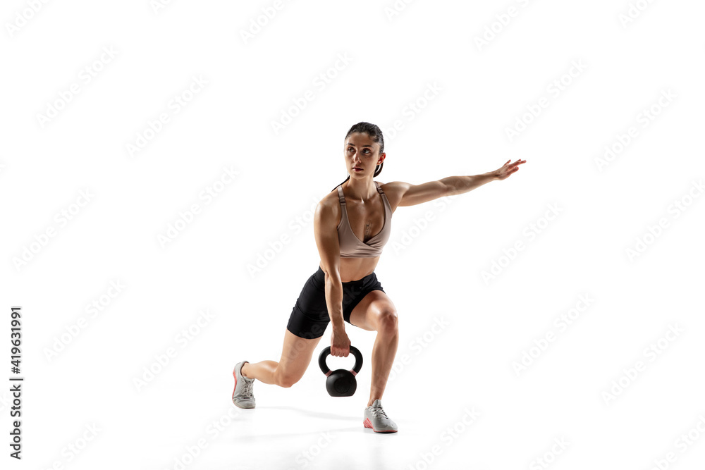 Squats with weight. Caucasian professional female athlete training isolated on white studio background. Muscular, sportive woman. Concept of action, motion, youth, healthy lifestyle. Copyspace for ad.