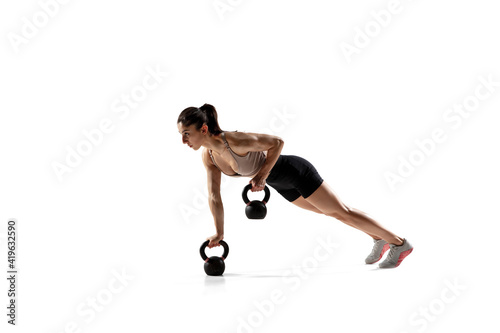 Balance. Caucasian professional female athlete training isolated on white studio background. Muscular, sportive woman. Concept of action, motion, youth, healthy lifestyle. Copyspace for ad.