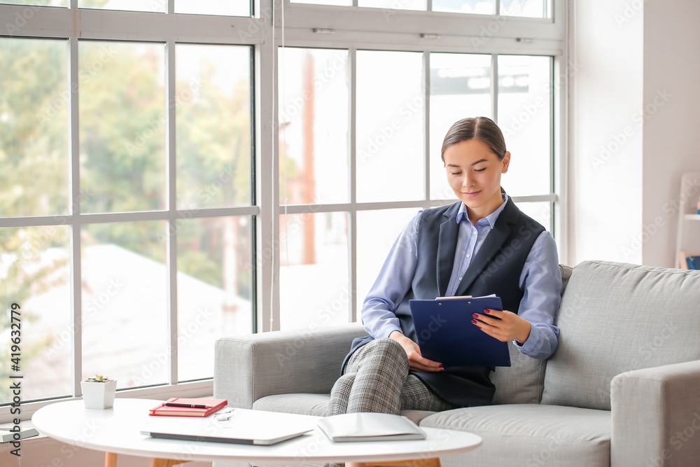 Portrait of female psychologist sitting on sofa in office