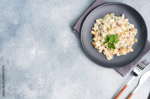 Olivier salad with mayonnaise on a plate. Russian is a traditional festive dish. photo