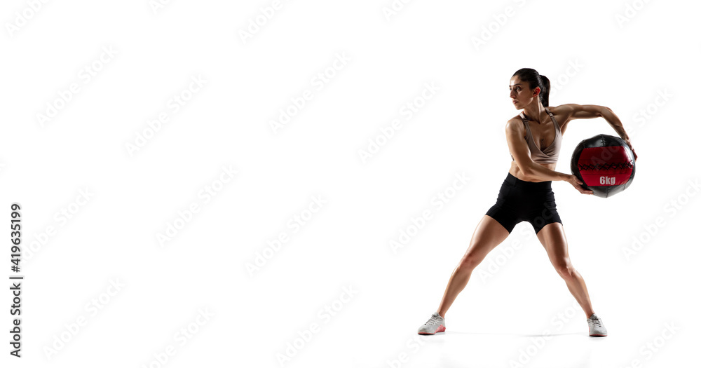Active, ball. Flyer. Caucasian professional female athlete training isolated on white studio background. Muscular, sportive woman. Concept of action, motion, youth, healthy lifestyle. Copyspace.