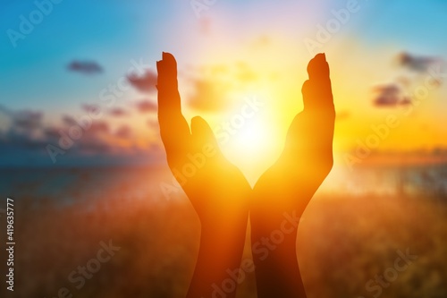 Female hands holding summer setting sun