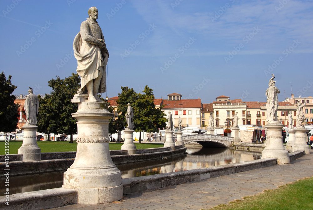 Prato della Valle is a large elliptical square with statues, fountains and colorful houses. It is the largest square in Padua and the largest in Europe.