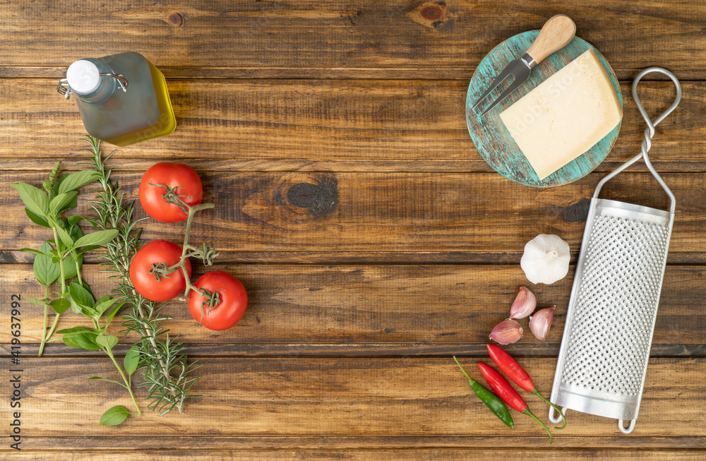 Tomatoes, olive oil, parmesan cheese, herbs and garlic over wooden table with copy space. Mediterranean food Tomatoes, olive oil, parmesan cheese, herbs and garlic over wooden table with copy space. Mediterranean food