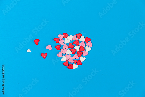 small white, pink and red hearts forming a bigger heart on blue background