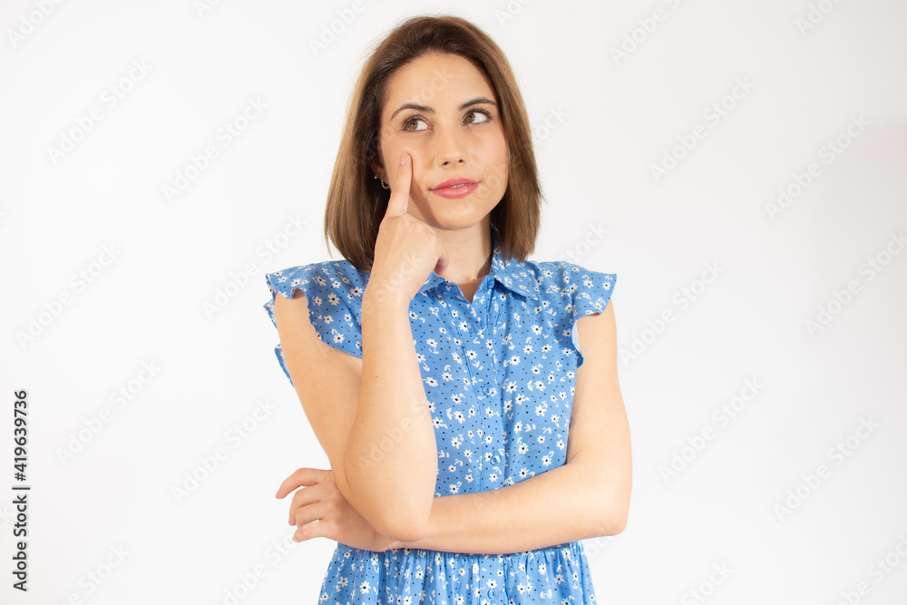 Pensive young woman in blue dress isolated over white background. Pensive young woman in blue dress isolated over white background.