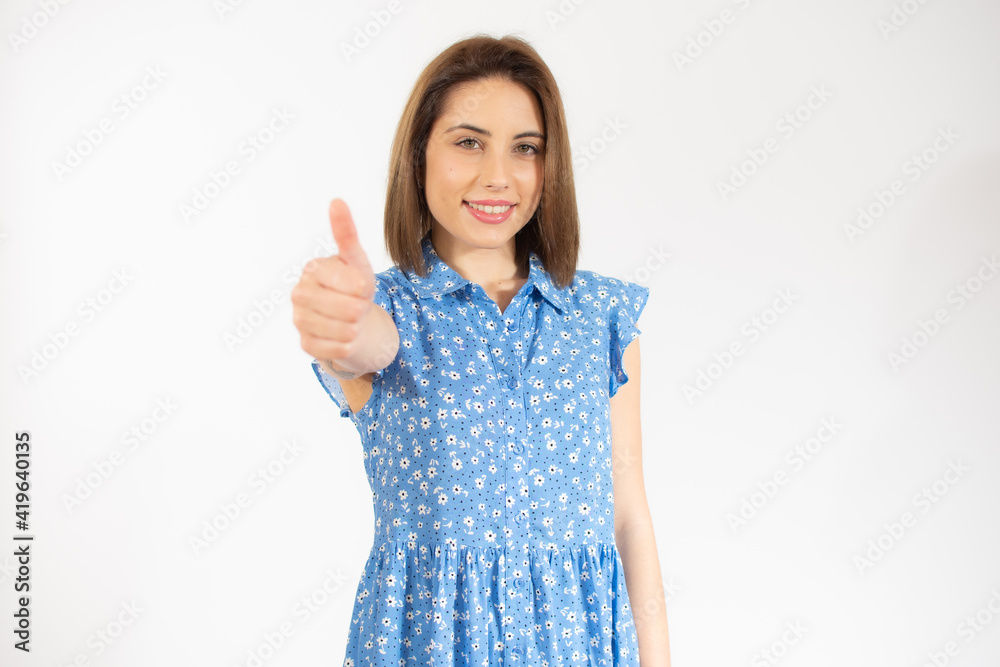 Smiling pretty young woman showing thumb up isolated over white background Smiling pretty young woman showing thumb up isolated over white background