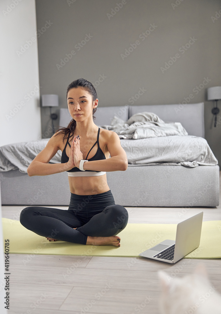 Fototapeta premium Happy beautiful asian woman is doing morning sport exercises at cozy bedroom