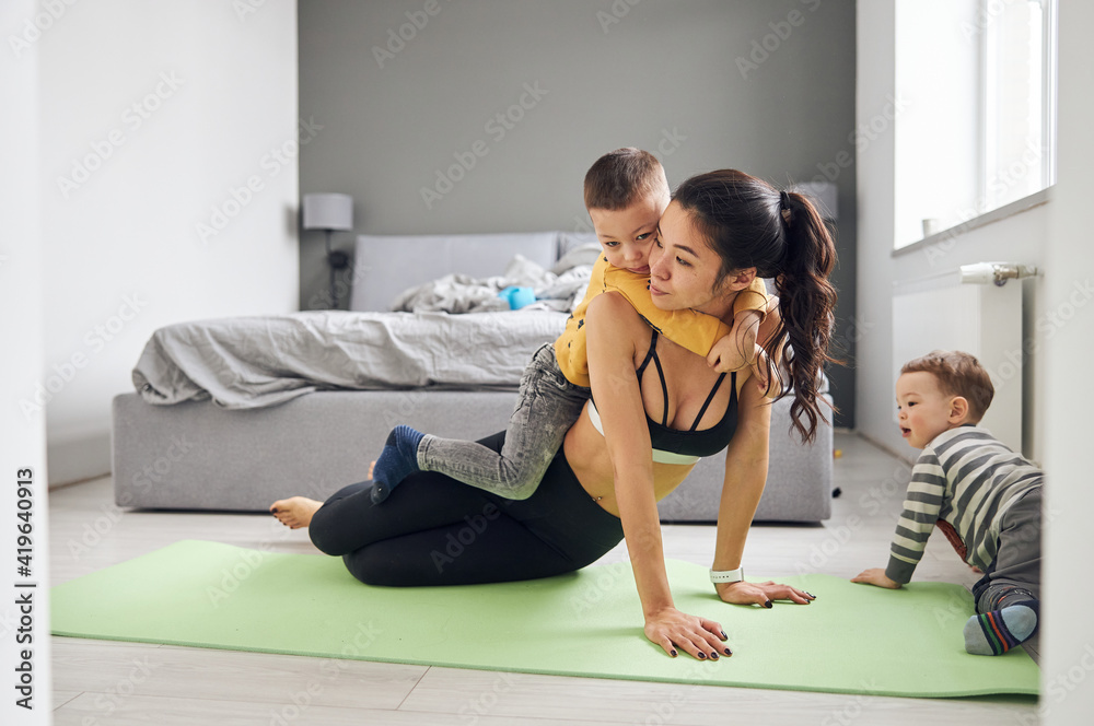 Happy beautiful asian woman is doing morning sport exercises at cozy bedroom Happy beautiful asian woman is doing morning sport exercises at cozy bedroom