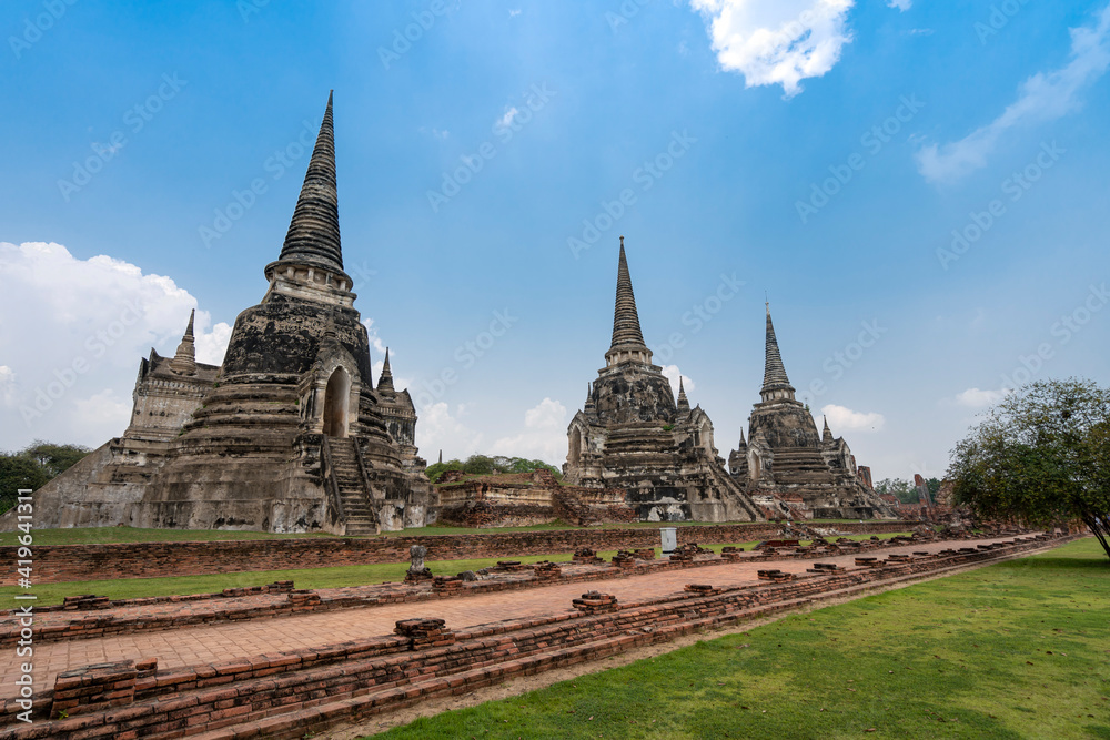 three ancient pagodas (chedies) ruins of old Siam capital Ayutthaya at Wat Phra Si Sanphet temple and walk way, famous place for travelling in Phra Nakhon Si Ayutthaya Province, Thailand  