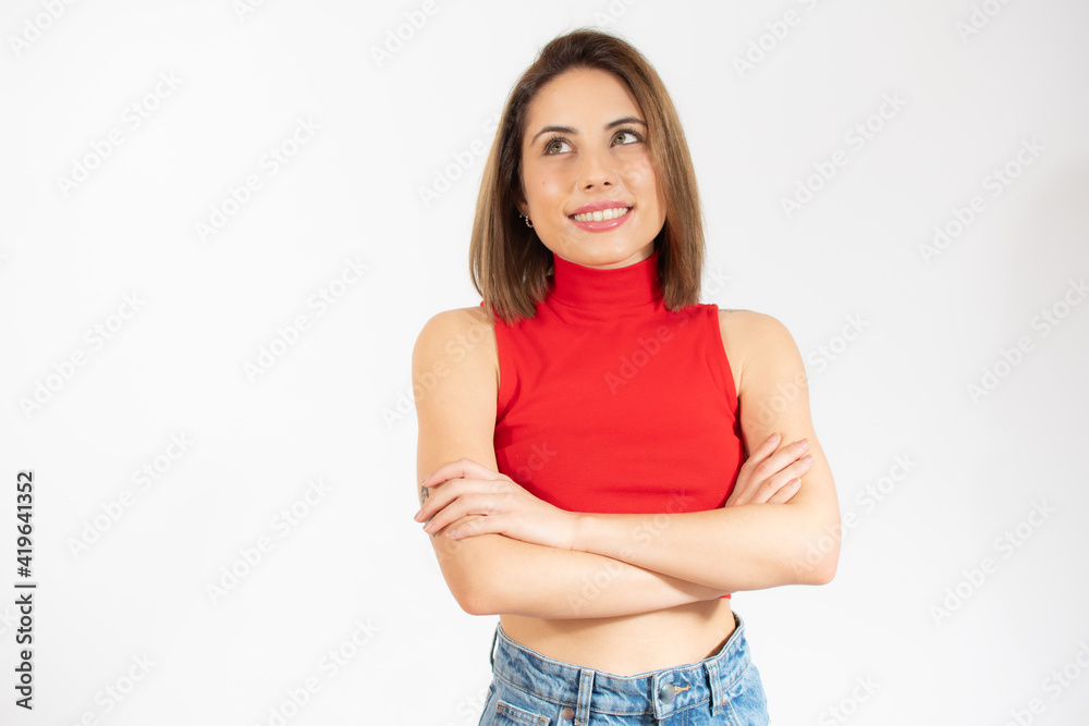 Portrait of a smiling young woman standing with arms folded isolated over white background Portrait of a smiling young woman standing with arms folded isolated over white background