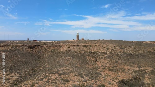 Aerial - Vlamingh Head Lighthouse in Pacific Ocean, Western Australia,  arid desert 
and blue sky, approach photo