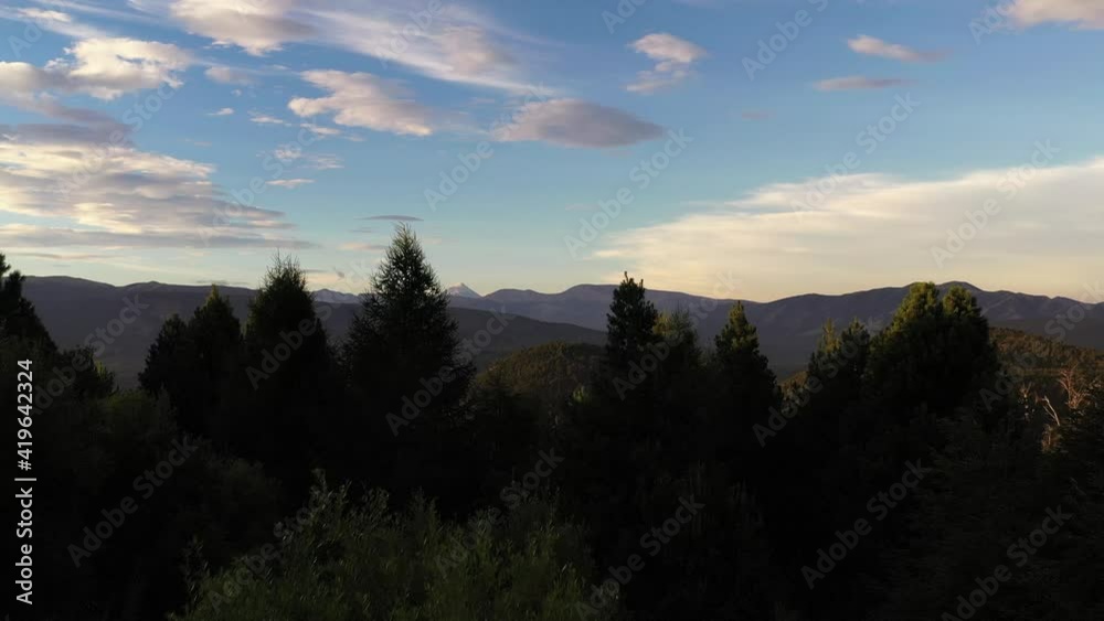 Aerial forward shot over treetops and beautiful andes landscape and Lanin Volcano during sunny day in Patagonia, Argentina Aerial forward shot over treetops and beautiful andes landscape and Lanin Volcano during sunny day in Patagonia, Argentina