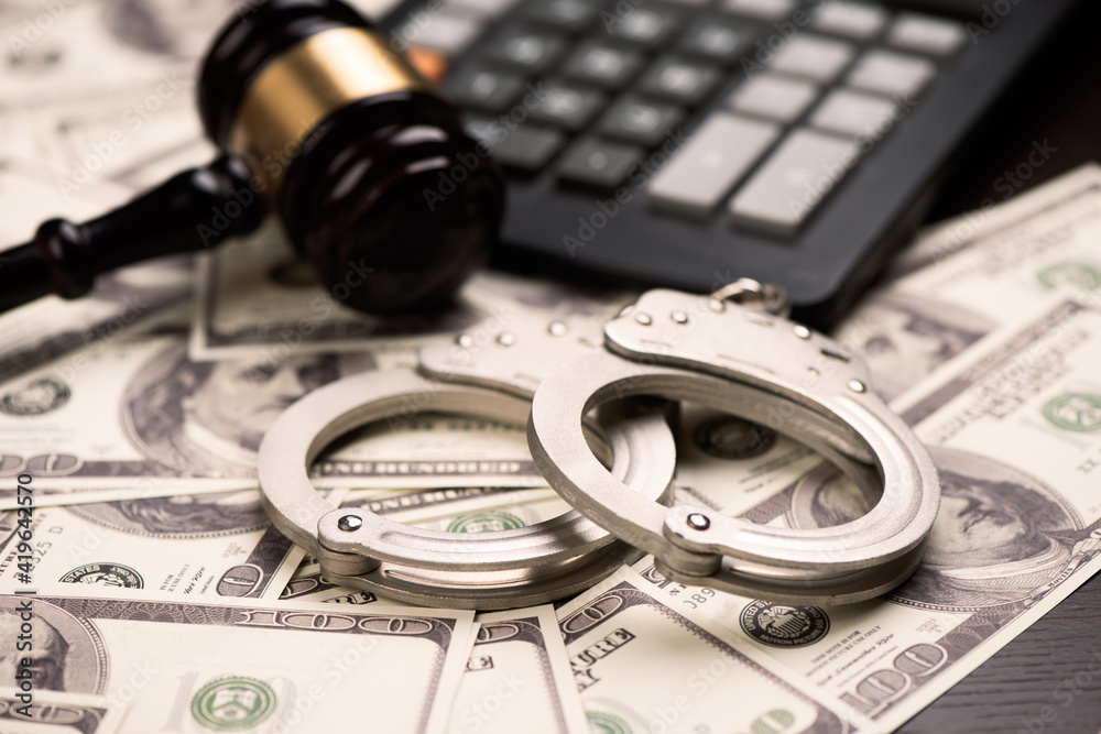 Hammer judge, handcuff and dollars on wooden table Hammer judge, handcuff and dollars on wooden table