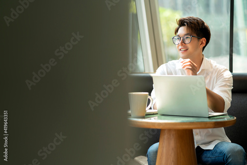 Smart attractive positive asian business male wearing glasses work remote new normal lifestyle hand use laptop tele conference onlive videocall meeting remote business ideas concept photo
