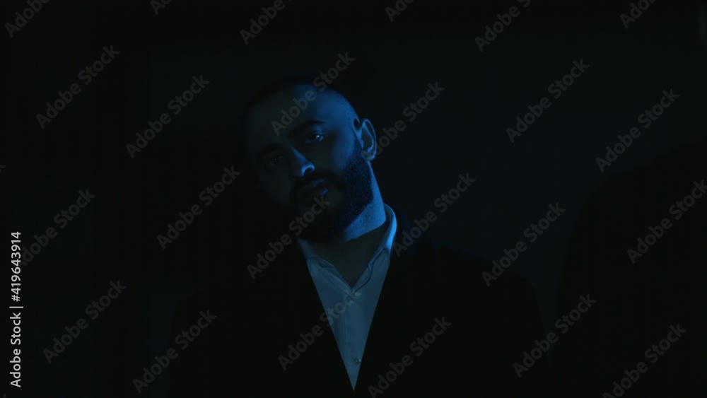 a man in a suit in a dark room a man in a suit in a dark room