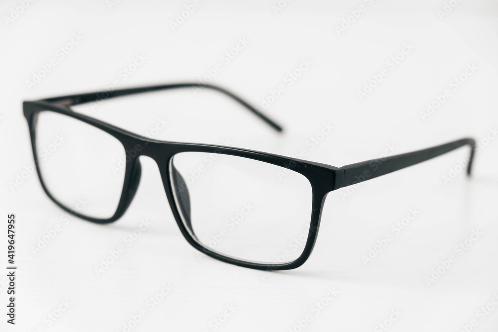 Optical glasses in a dark frame on a white background. Copy, empty space for text