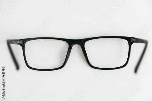 Optical glasses in a dark frame on a white background. Copy, empty space for text