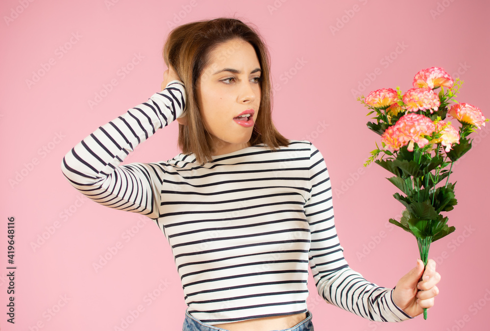 Smiling woman holding flowers over pink background Smiling woman holding flowers over pink background