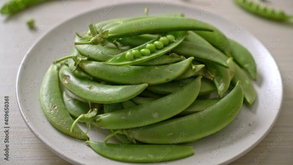 fresh sweet green peas on white plate fresh sweet green peas on white plate