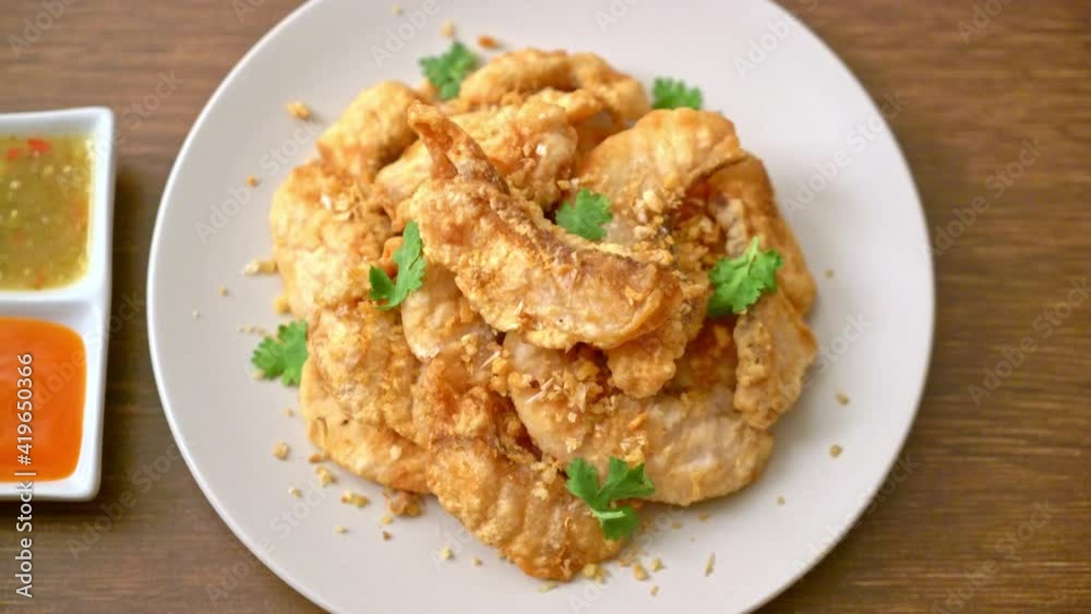 fried fish with garlic on plate fried fish with garlic on plate