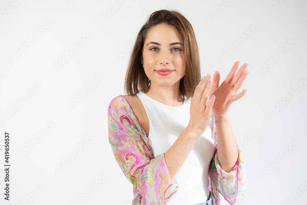 young pretty woman feeling happy and successful, smiling and clapping hands, saying congratulations with an applause over white background. young pretty woman feeling happy and successful, smiling and clapping hands, saying congratulations with an applause over white background.
