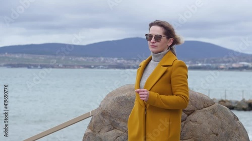 Medium shot of a young beautiful girl on the beach talking on the phone