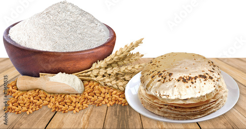 A rustic shot of a plate of chapati surrounded by ingredients