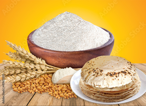 Wheat flour Bunch of wheat ears, dried grains in wooden bowl, flour in wooden bowl on white background. Cereals harvesting, bakery products
