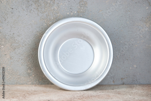 Metal bowl on a concrete background.