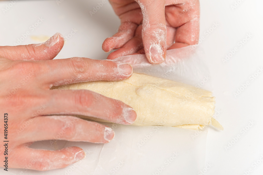 Hands of chef prepares an apple roll. Process of making a dessert.