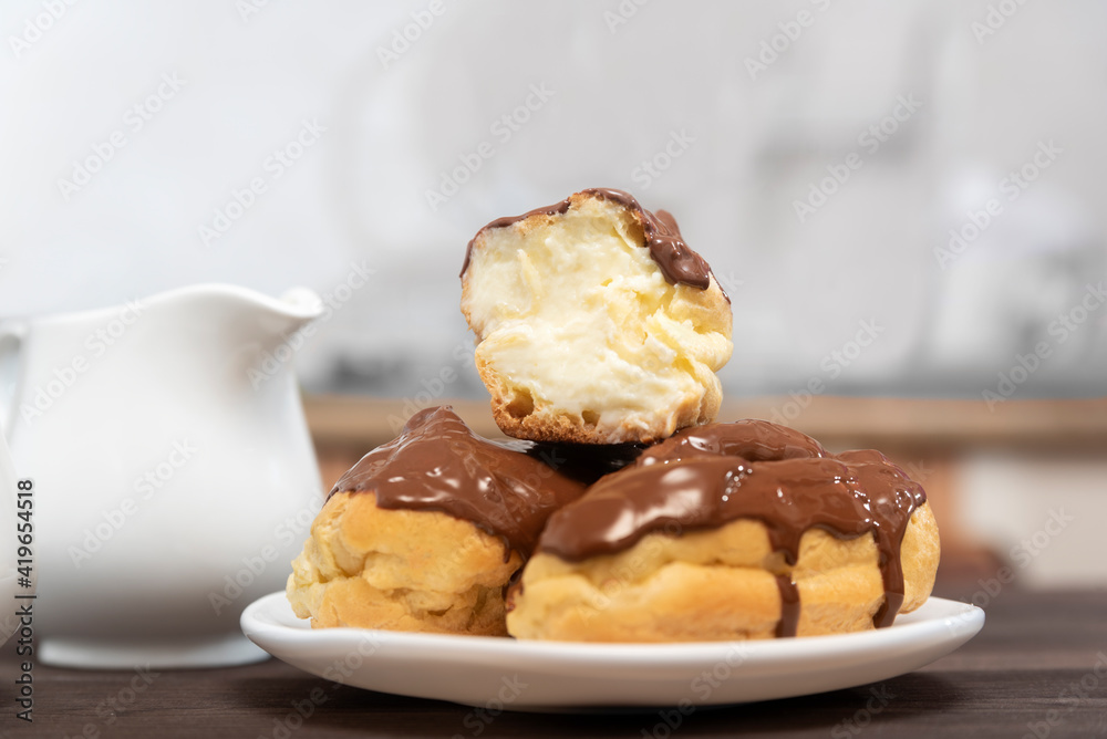 Cut eclair with cream poured with chocolate, close-up. Sweet dessert Cut eclair with cream poured with chocolate, close-up. Sweet dessert