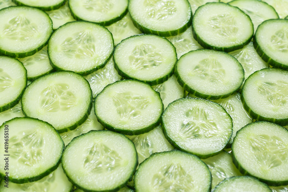 Fresh green slices of cucumber as background. Fresh green slices of cucumber as background.