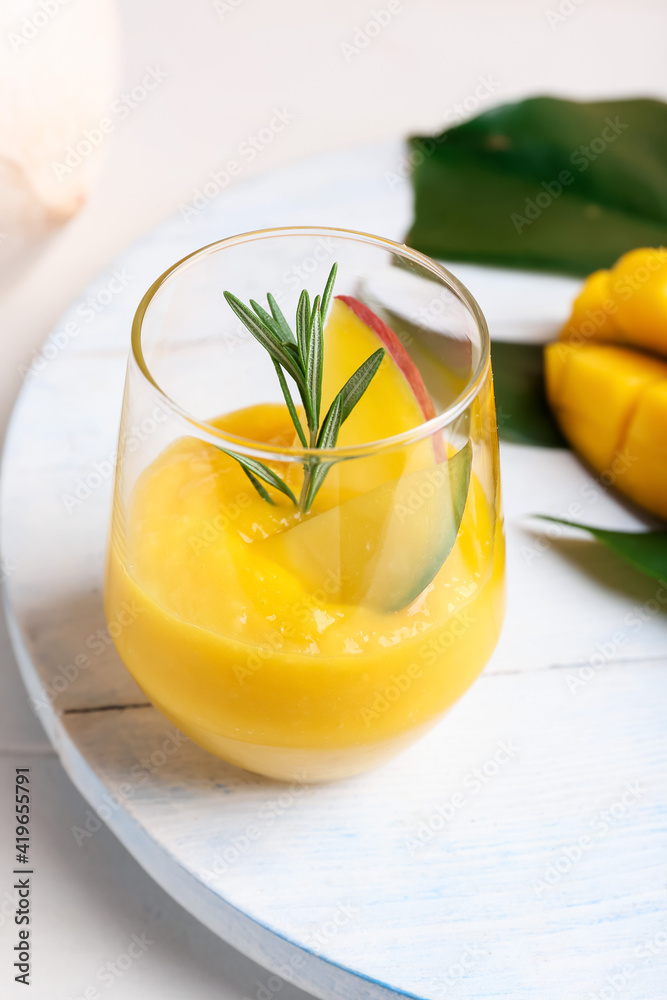 Glass of tasty mango margarita on light wooden background Glass of tasty mango margarita on light wooden background