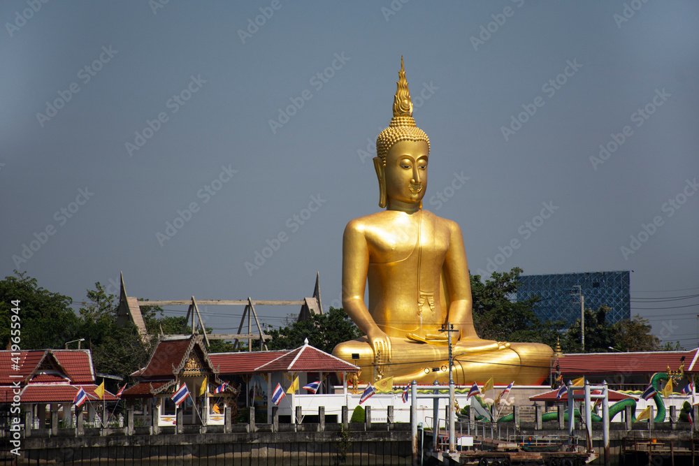 Golden big buddha image statue of Wat Bang Chak temple at riverside chao phraya river near Koh Kret island for thai people trave visit and respect praying at Pak kret city in Nonthaburi, Thailand