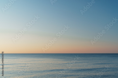 Horizontal line between sea and sky at sunset.