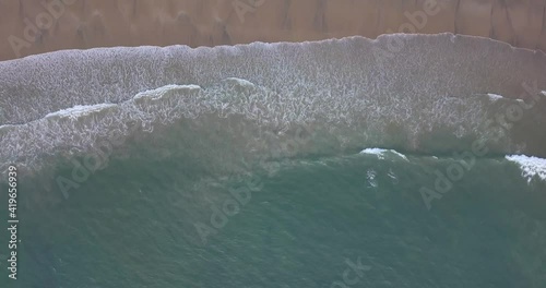 Top Down View Of Turquoise Ocean And Waves Washing The Empty Sandy Beach - Galgibaga Beach, Canacona, South Goa, India - aerial drone shot photo