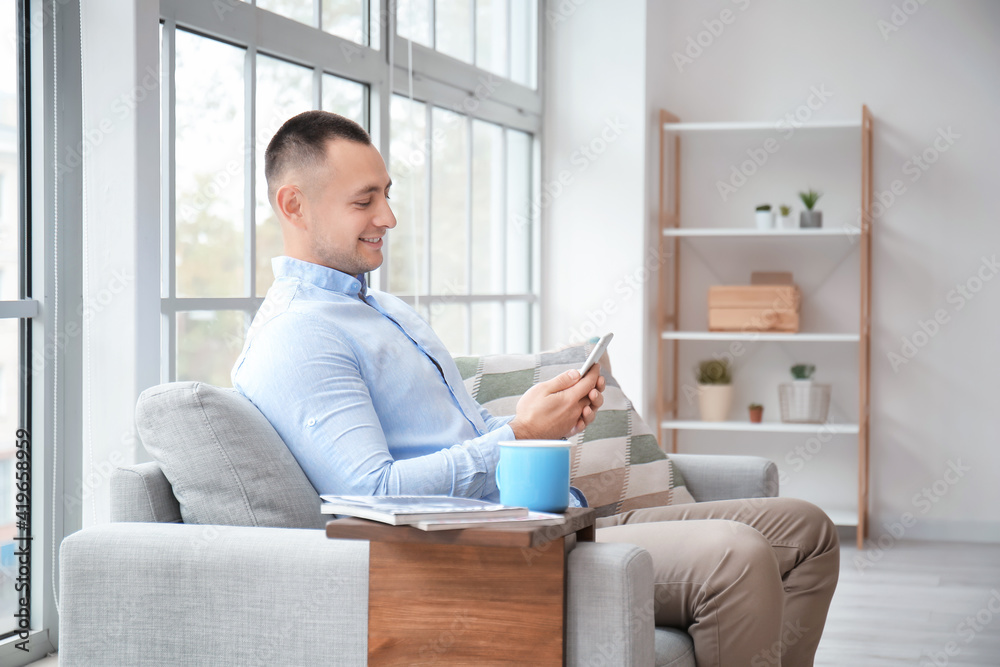 Handsome young man with mobile phone at home Handsome young man with mobile phone at home