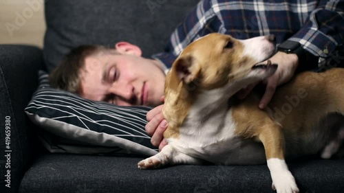 Teenager playing with a dog at home.