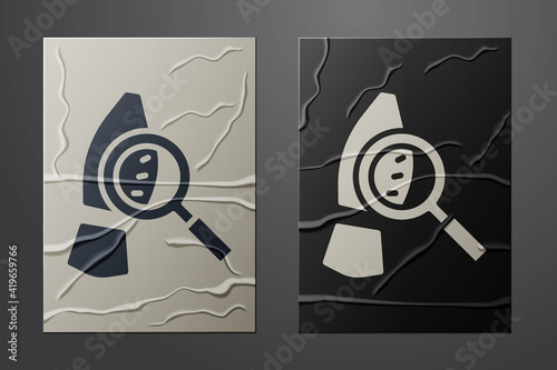 White Magnifying glass with footsteps icon isolated on crumpled paper background. Detective is investigating. To follow in the footsteps. Paper art style. Vector.