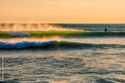 Ocean wave at warm sunset or sunrise. Waves and strong wind with evening light