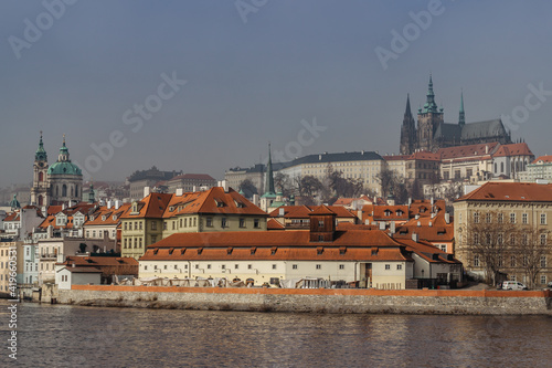 Postcard view of Prague Castle in mist from Charles Bridge,Czech republic.Famous tourist destination.Prague panorama.Foggy morning in city.Amazing European cityscape.Inversion weather outdoors