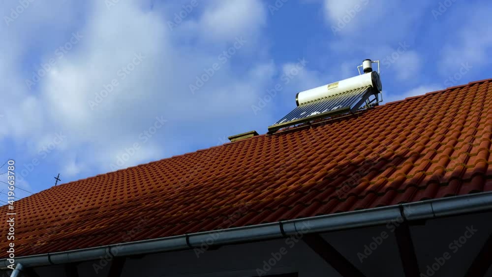 Solar water heater boiler on rooftop, fast moving clouds timelapse footage. Solar water heater boiler on rooftop, fast moving clouds timelapse footage.