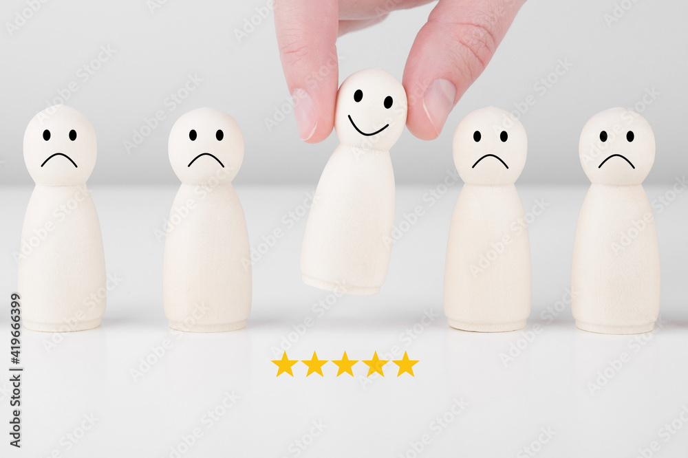 Wooden man gives a 5-star rating and a smiley face. Concept of customer service and satisfaction survey. Wooden man gives a 5-star rating and a smiley face. Concept of customer service and satisfaction survey.
