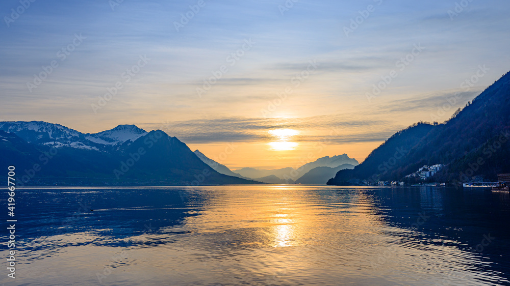 Sunset over Lake Lucerne. Silhouettes of the Alps mountains.