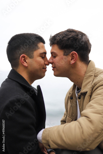  portrait of a homosexual young couple on the beach loving each other