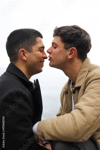  portrait of a homosexual young couple on the beach loving each other